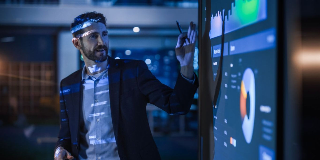 Conference Business Meeting Presentation: CEO Businessman Shows Data to Group of Investors, Businessspeople. Projector Screen Shows Graphs, Product Sales, Revenue Growth Strategy, e-Commerce Analysis